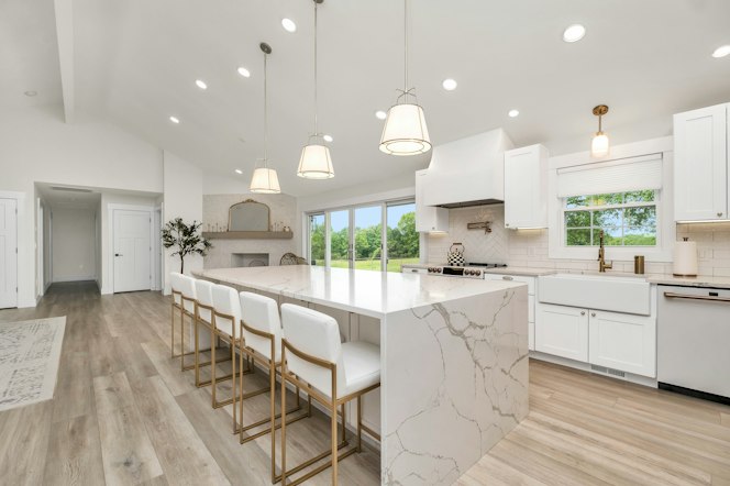 Kitchen Remodeling Large kitchen with a marble island and white cabinets